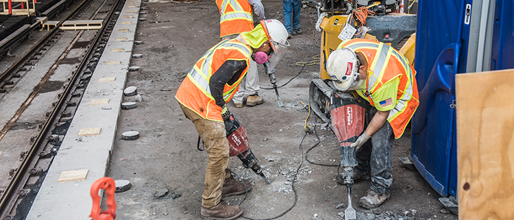 Construction crews jackhammering station platforms